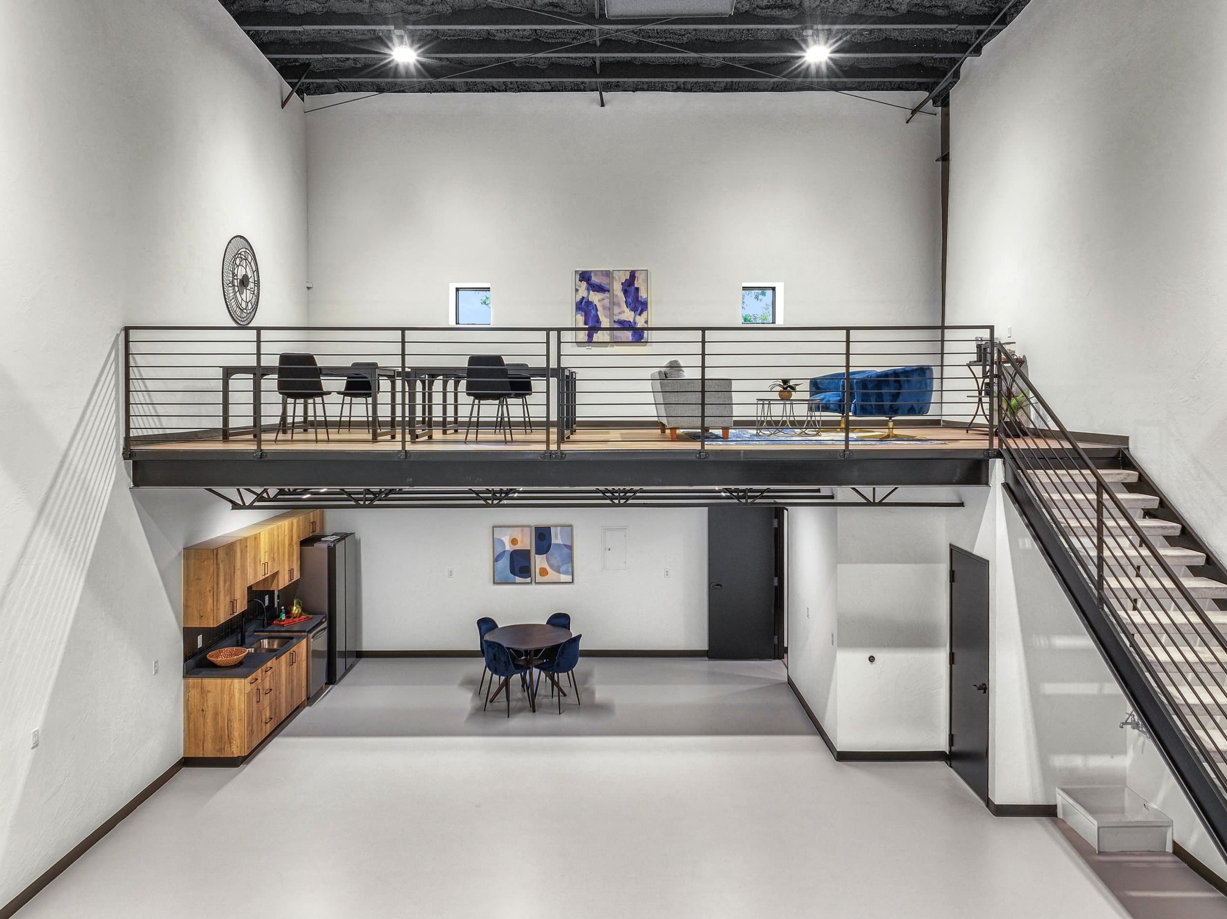 Commercial loft suite with a steel mezzanine and exposed black ceiling