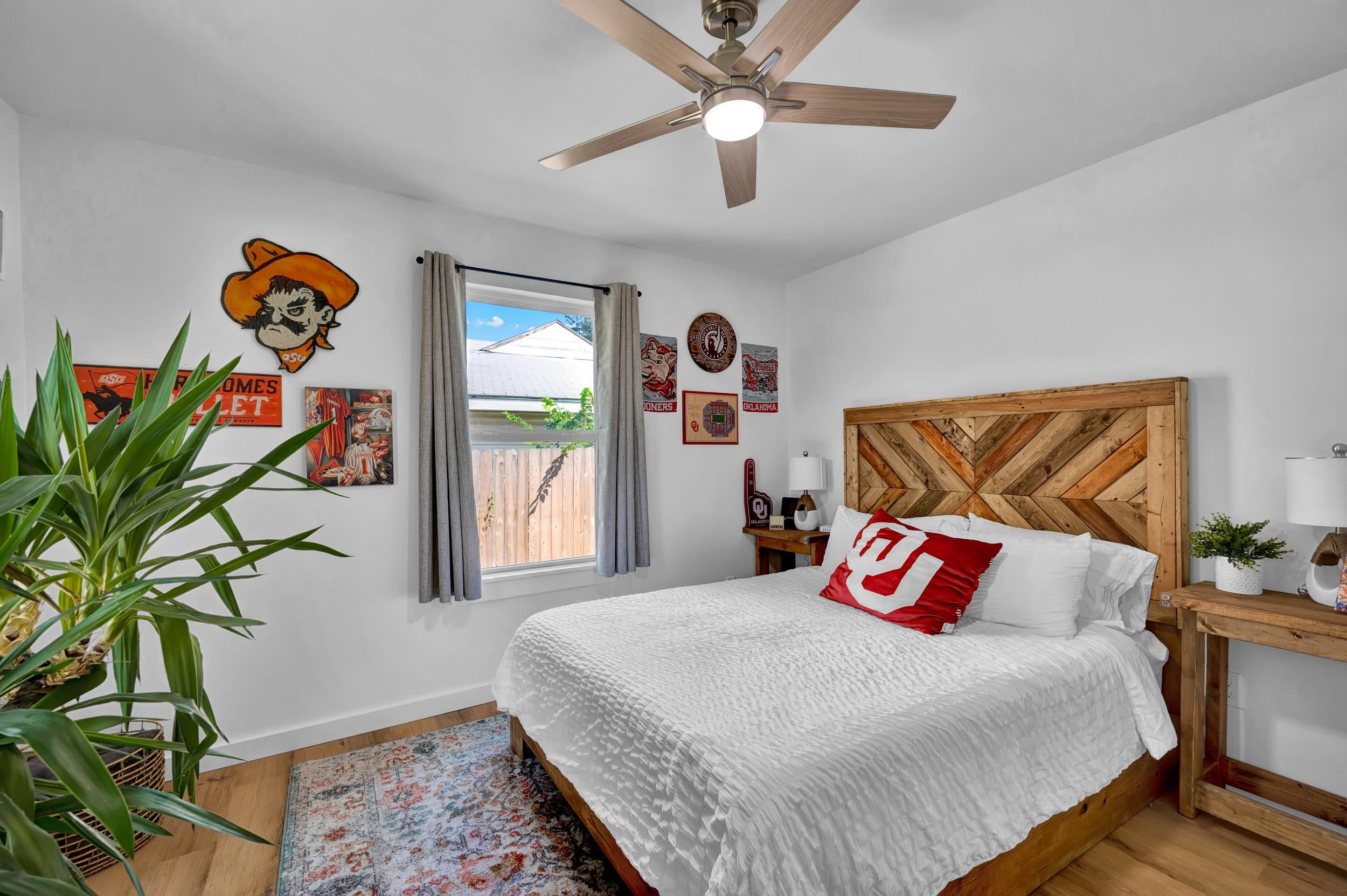 Bedroom with a reclaimed-wood chevron headboard and Oklahoma team memorabilia