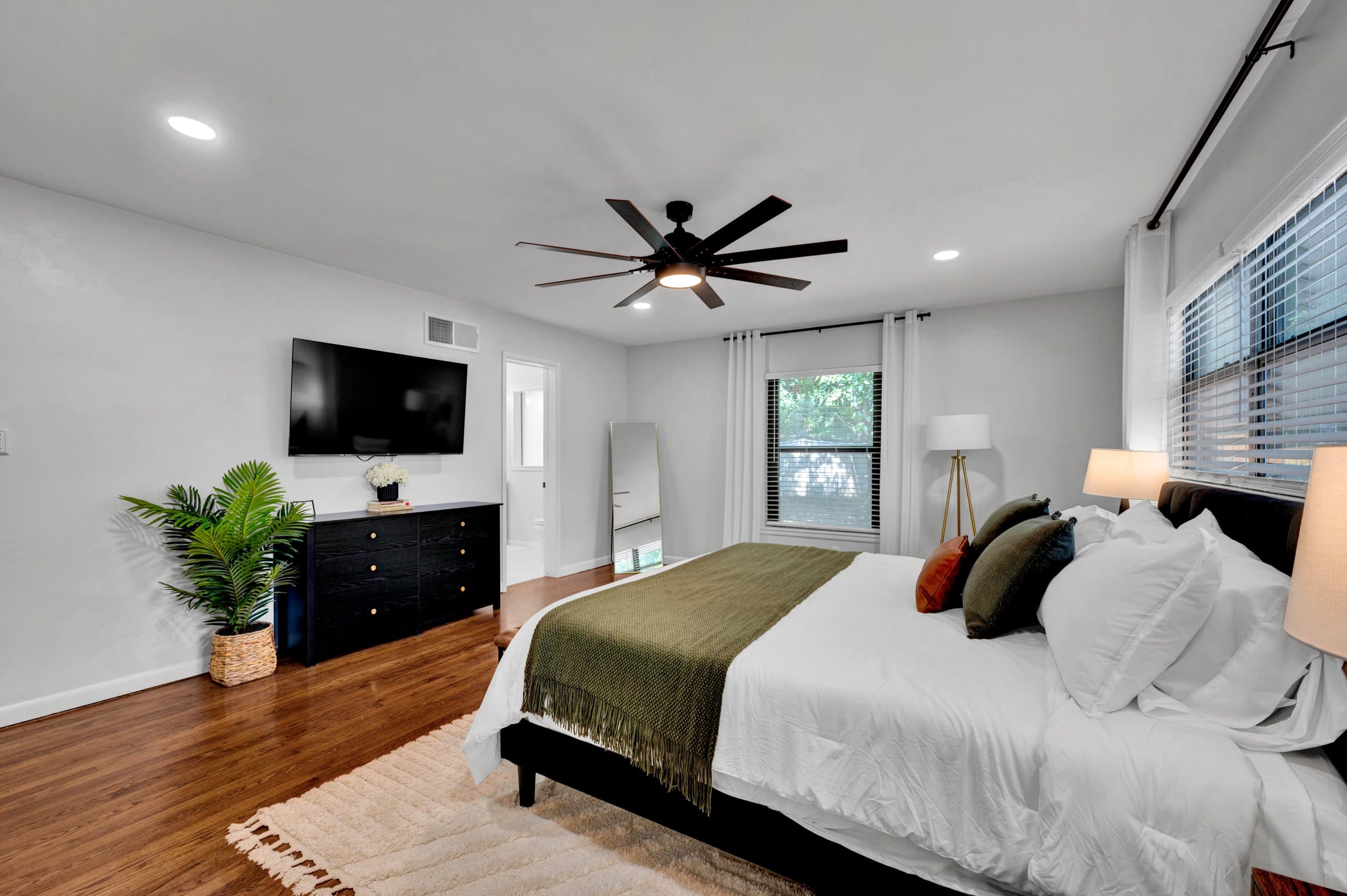 Guest bedroom with a mounted television and layered bedding