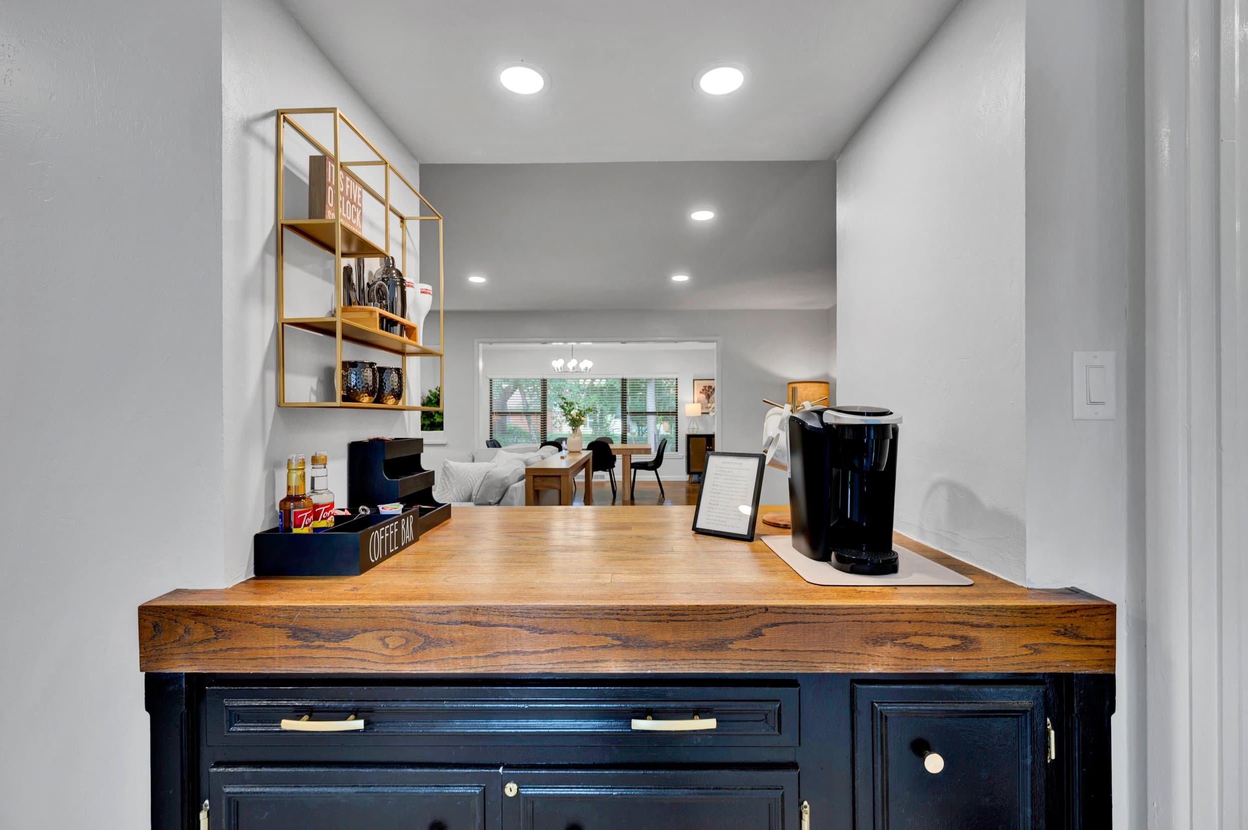 Guest coffee bar set up with a brewer, syrups and a house-rules card