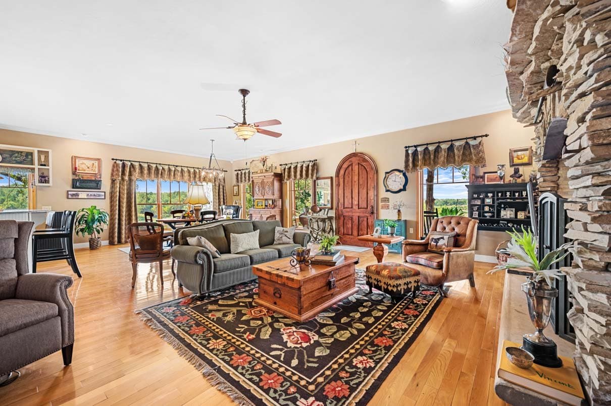 Traditional great room with a stone fireplace and a wall of windows