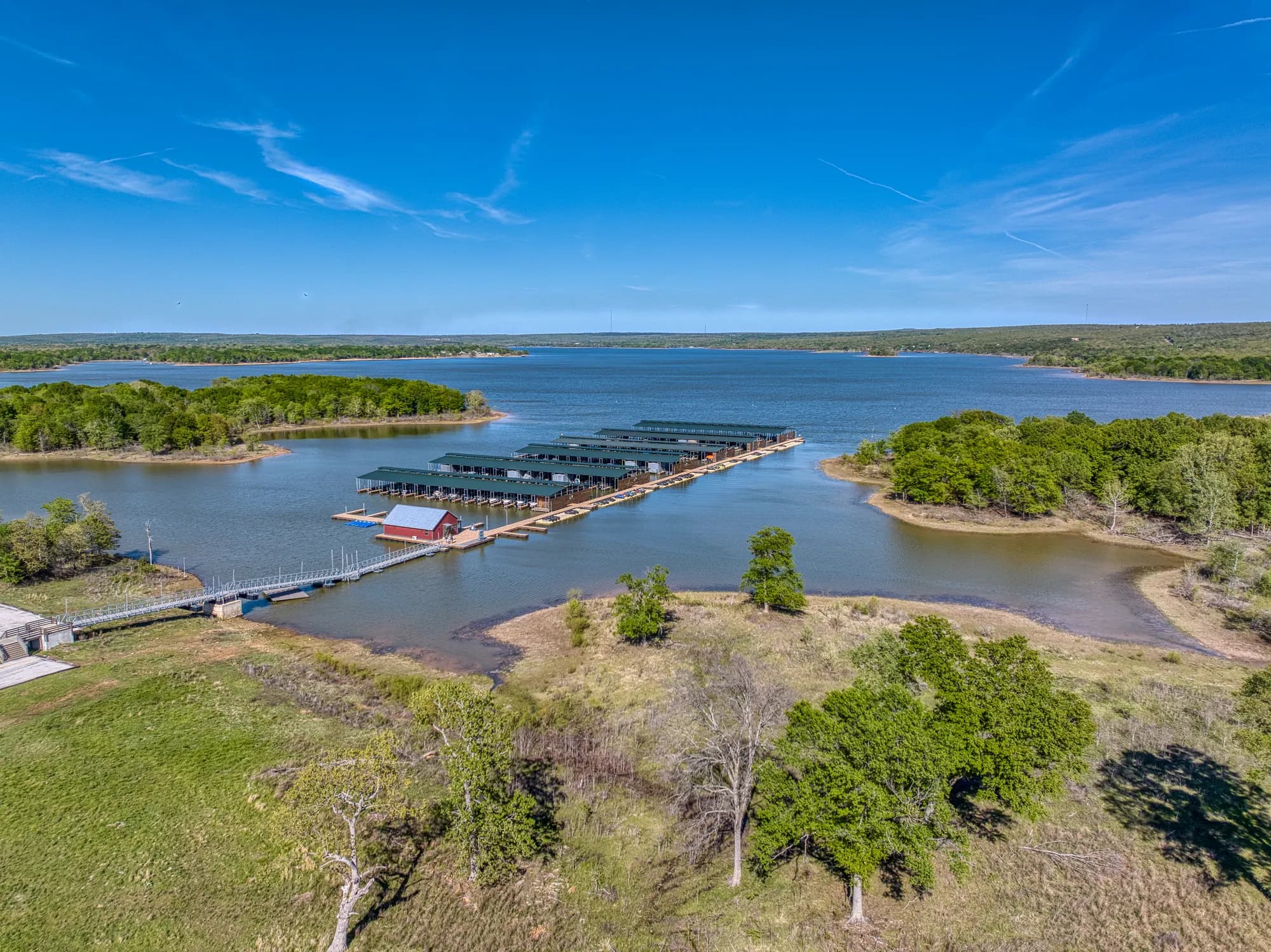 Aerial view of a lakeside marina and wooded shoreline