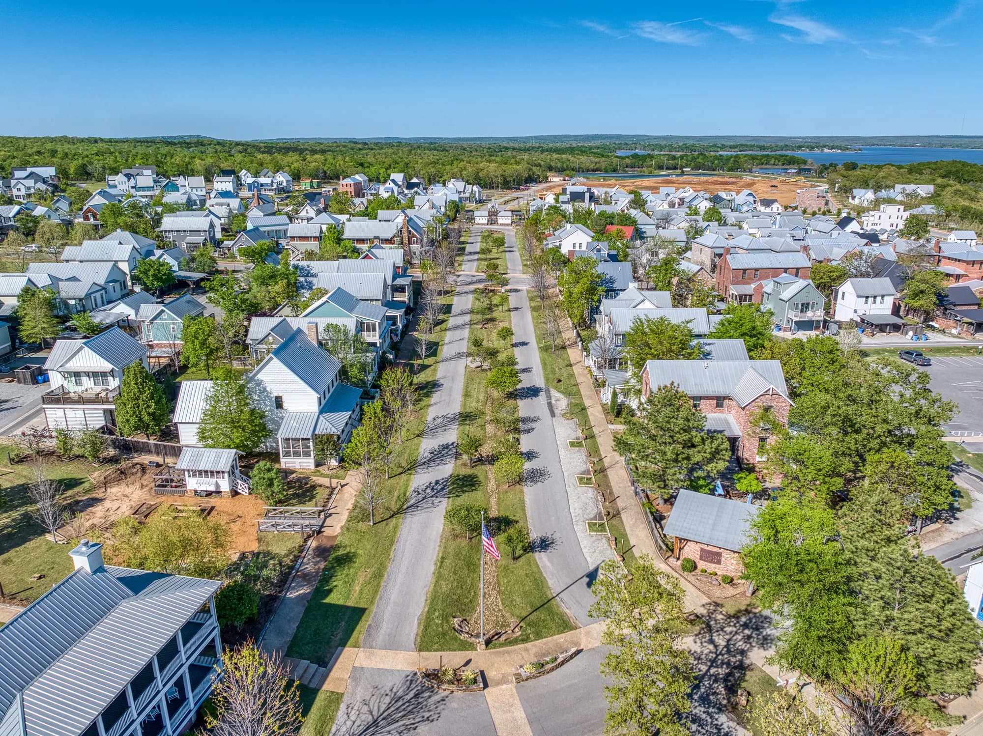 Aerial view down a tree-lined street toward the lake