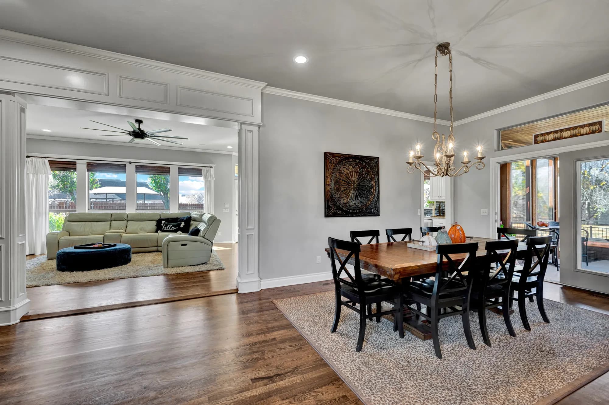Formal dining room with a beaded chandelier opening to the living room
