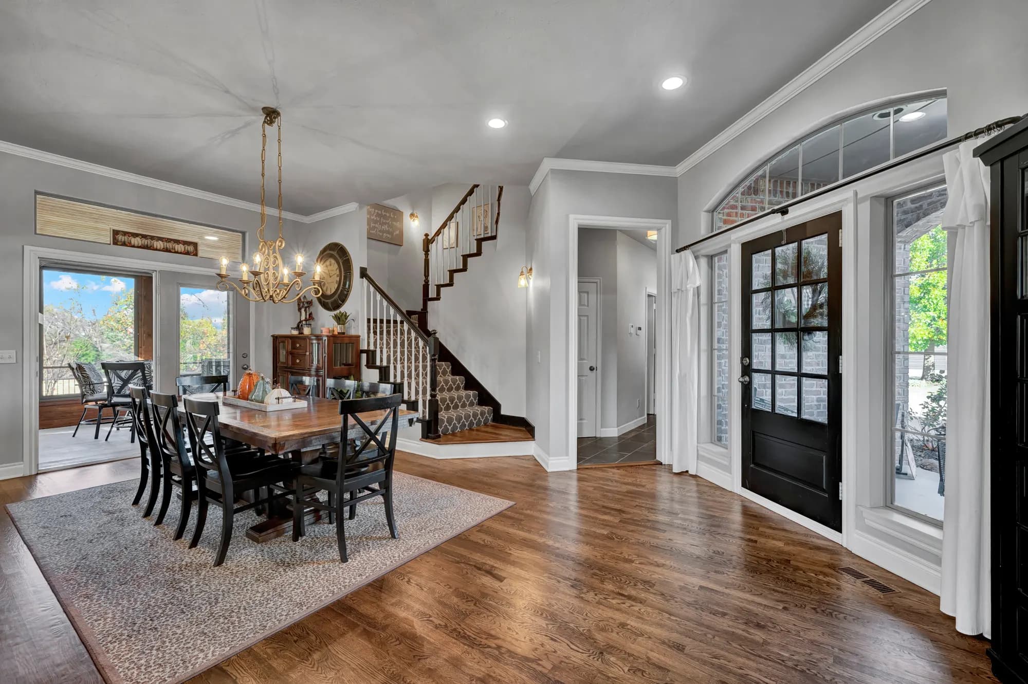 Entry hall with a glass front door, chandelier and curved staircase