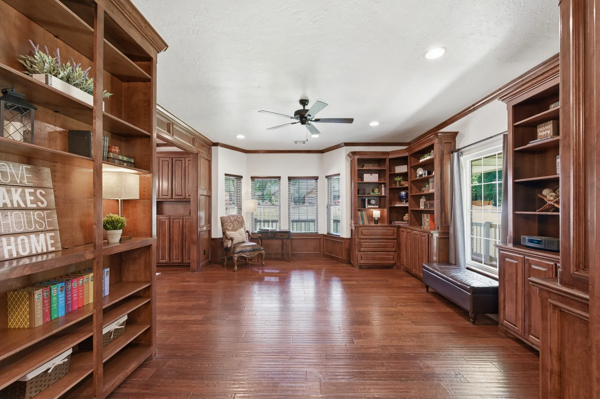 Study lined with stained wood built-ins and a bay window