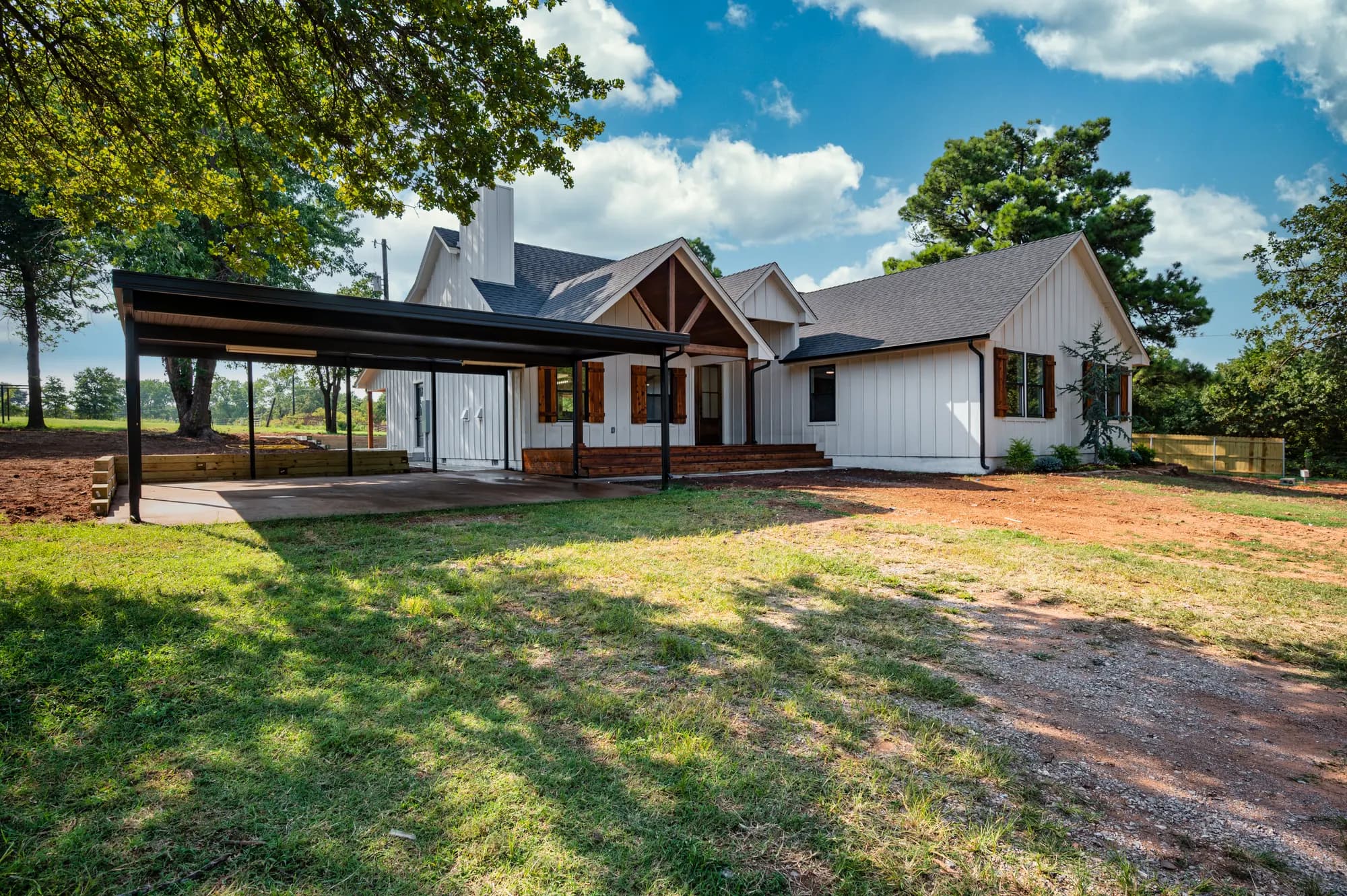 Modern farmhouse exterior in Guthrie with a covered patio and metal roof