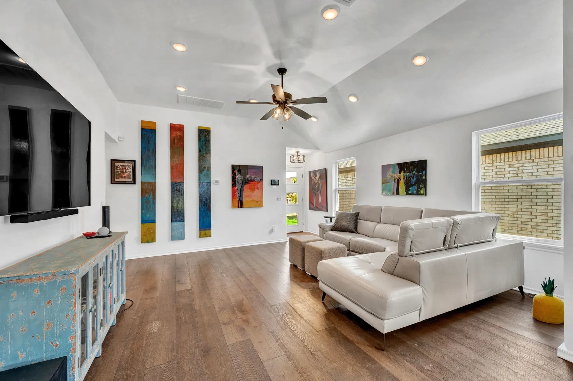 Living room with a sectional sofa, gallery wall and wide-plank floors