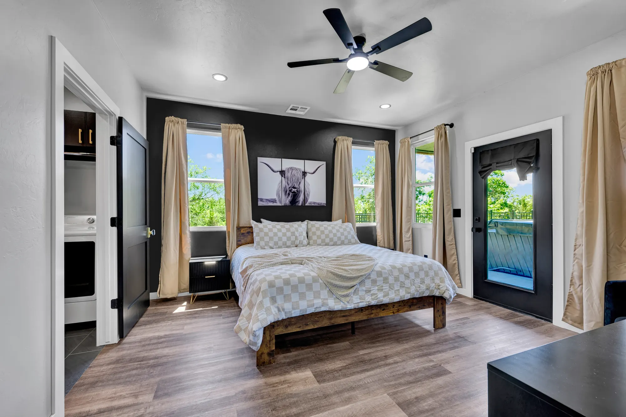 Guest bedroom with a black accent wall and a private balcony door