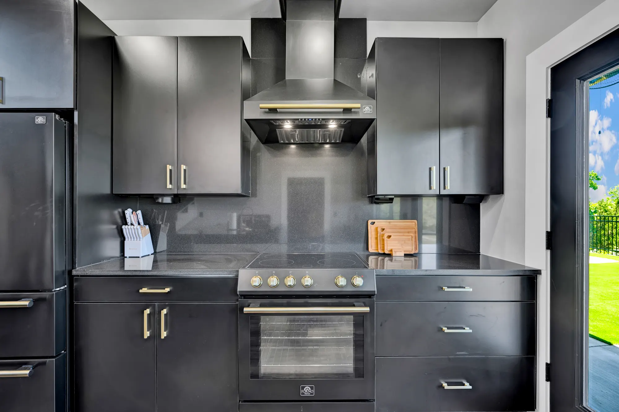 Charcoal rental kitchen with a chimney hood and brass hardware