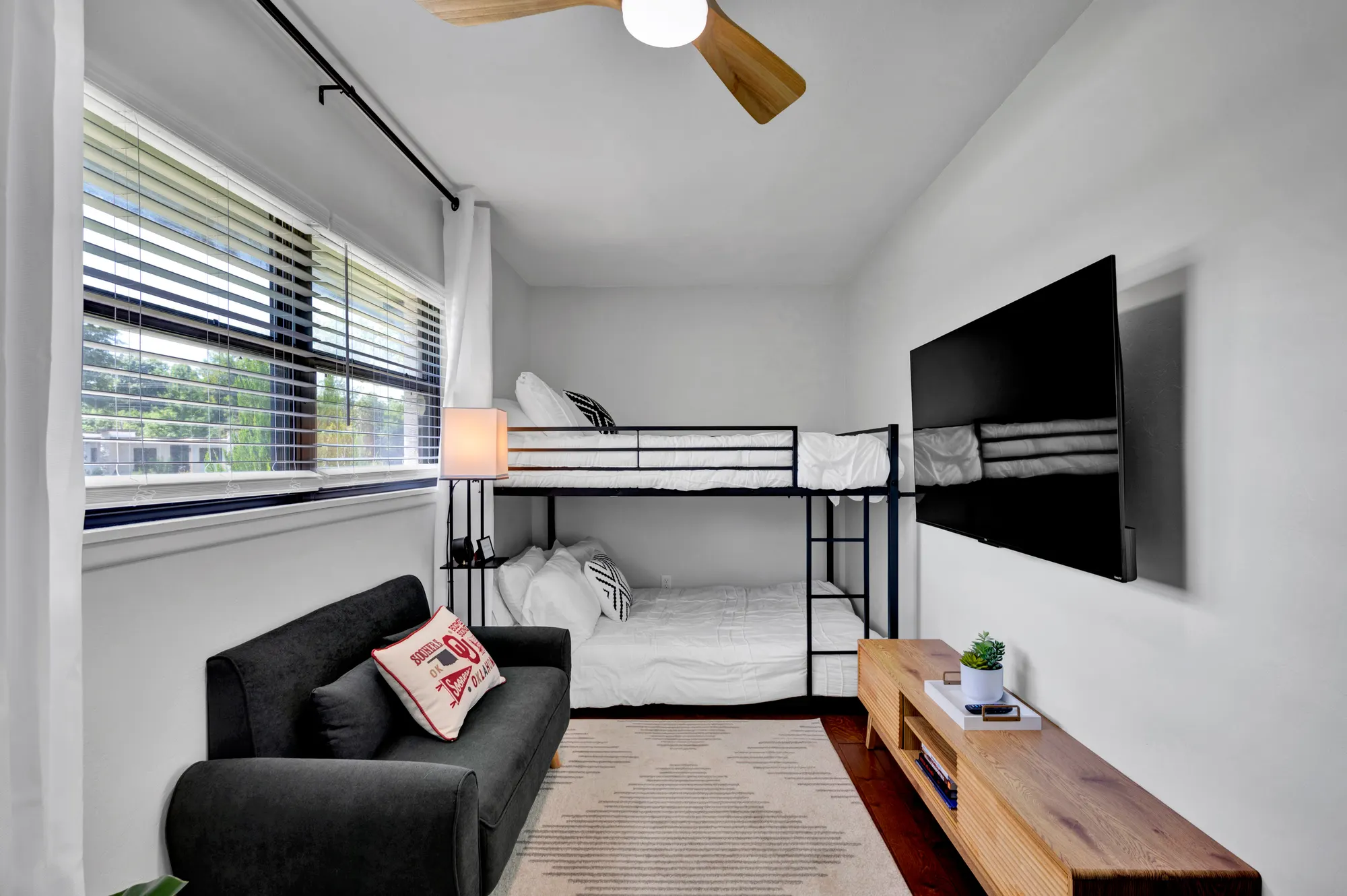 Bunk room with a sofa and television for younger guests