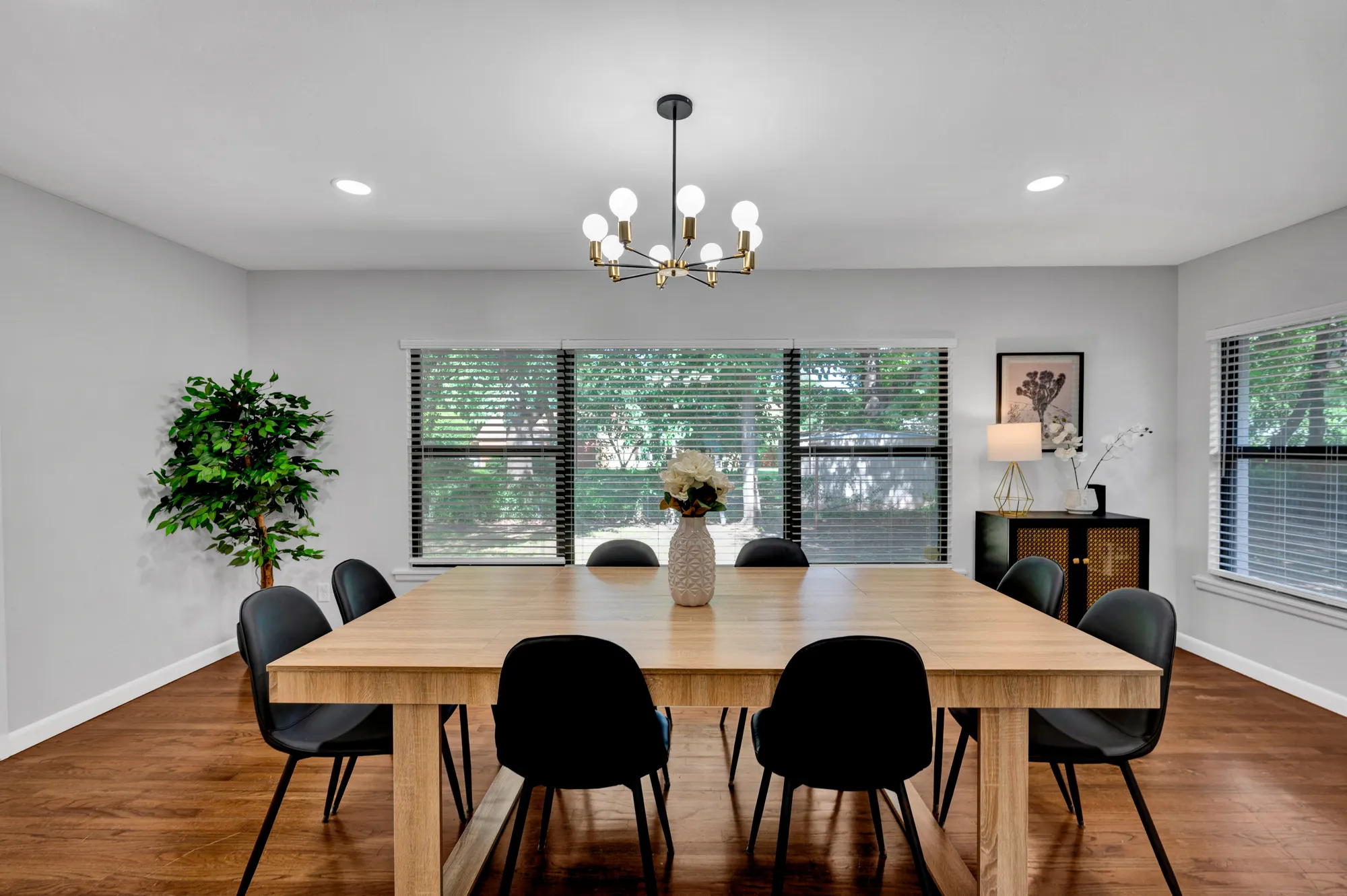 Rental dining room with a light oak table and a brass chandelier