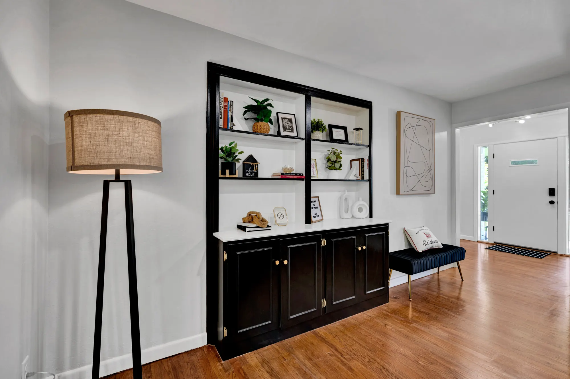 Entry and sitting area with black built-in shelving styled for guests